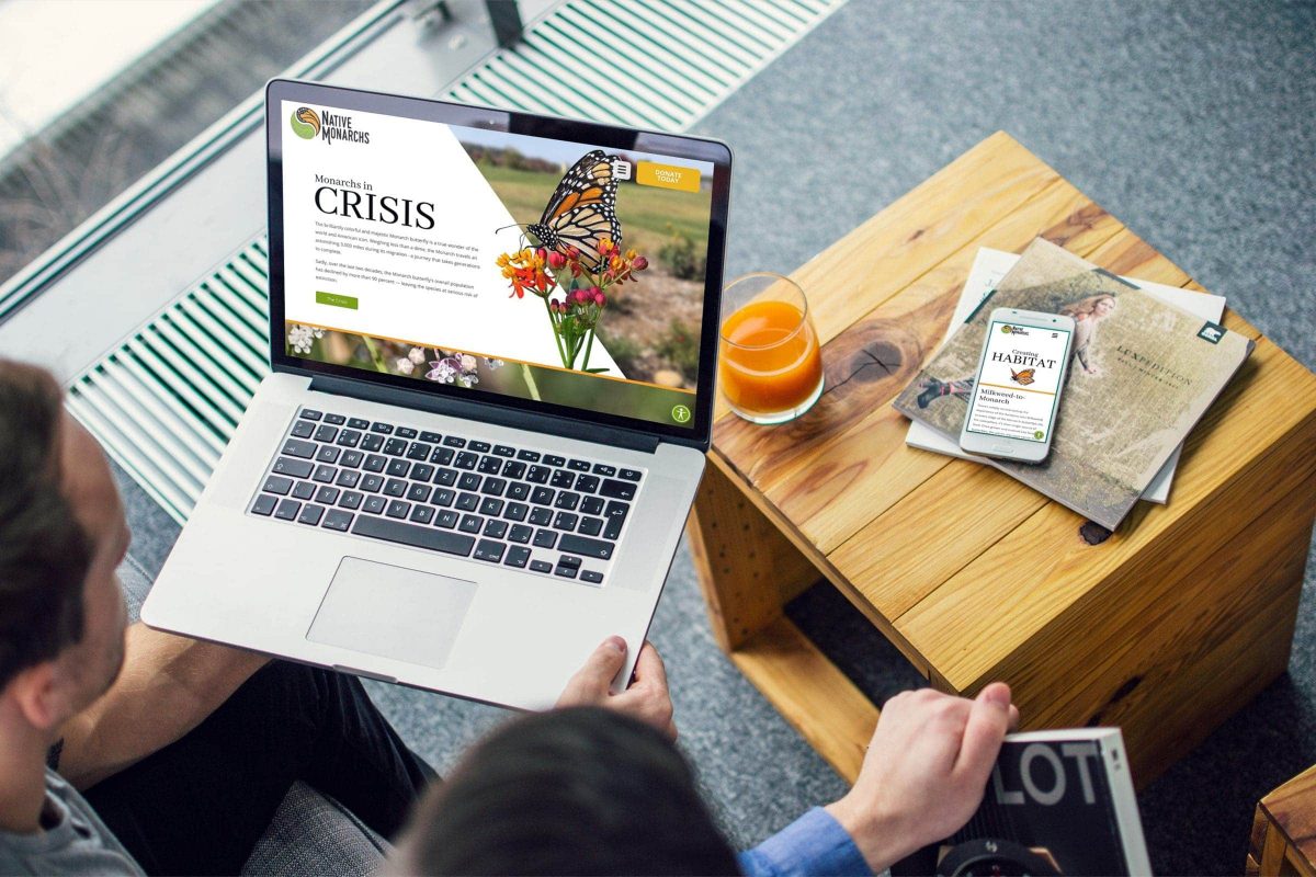 In a casual university setting two people browse NativeMonarchs.org on a laptop and an iphone