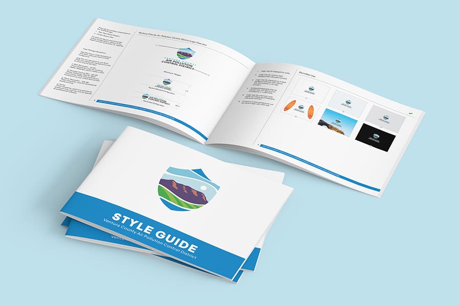 VCAPCD_Portfolio_01 Open style guide booklets showcasing logo designs and branding guidelines on a light blue background, thoughtfully incorporating elements from Ventura County's Air Pollution Control initiatives.