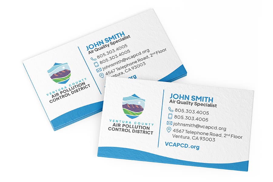 VCAPCD_Portfolio_04 Two business cards for John Smith, Air Quality Specialist at Ventura Countys Air Pollution Control District. The cards feature contact details and a thoughtfully designed logo and branding with mountains and waves.