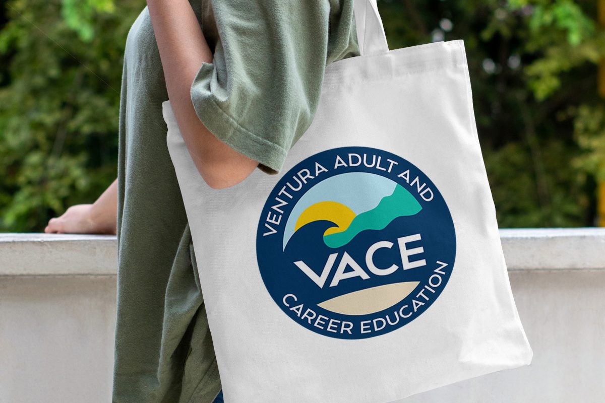 Person holding a tote bag with Ventura Adult and Career Education logo.